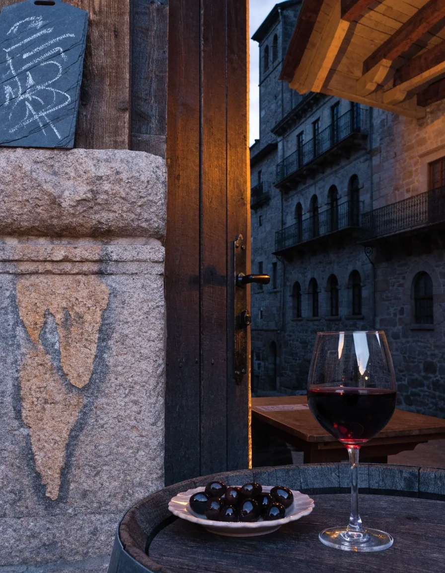 Interior de una pequeña taberna de piedra en Santiago de Compostela con luz de tarde entrando por una ventana estrecha